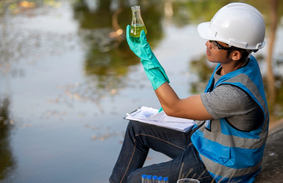 A geo-environmental consultant reviewing water samples taken during a contaminated land risk assessment